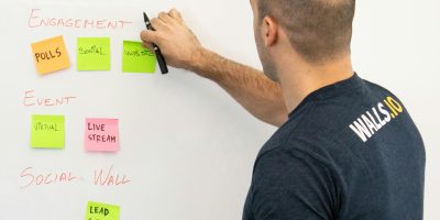 Man analyzing marketing content strategies using sticky notes on a whiteboard.